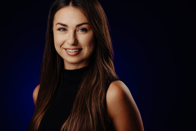 Cinematic Headshot: kobieta na granatowym tle, miękkie światło na twarzy